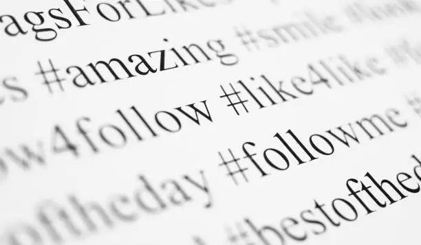 Photo of Closeup of typed popular hashtags. Words on the paper sheet.