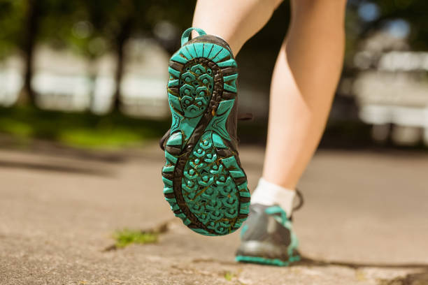 istock Woman in running shoes jogging on path 824033190