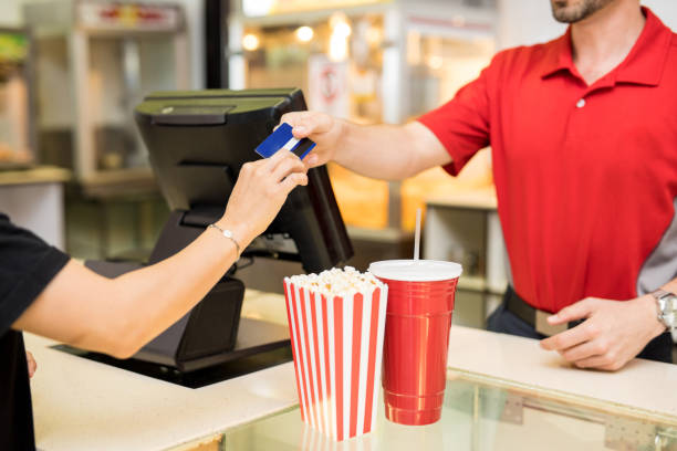 mujer pagando para aperitivos en el cine - cinta para caja registradora fotografías e imágenes de stock