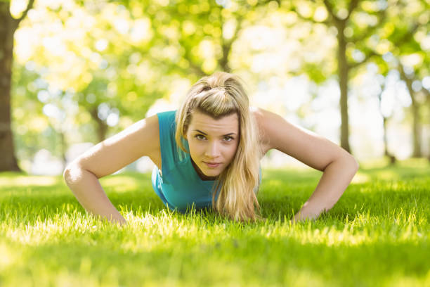 istock Fit blonde doing push ups in the park 824033594