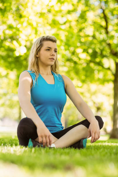 istock Fit blonde sitting on the grass 824033900