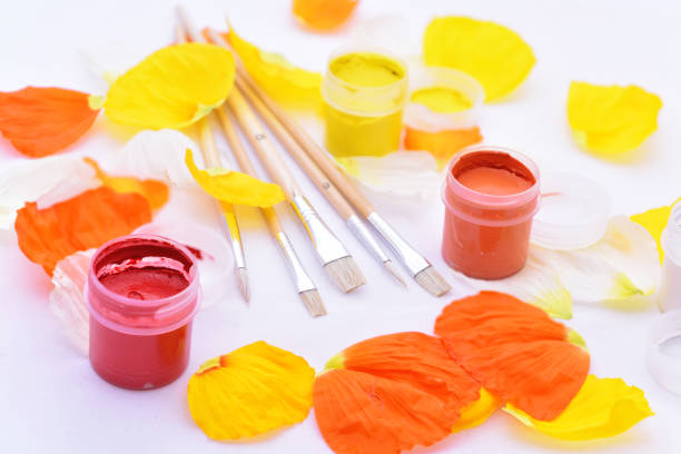 Colored abstraction of brushes for drawing. Flower leaves with gouache on white table.
