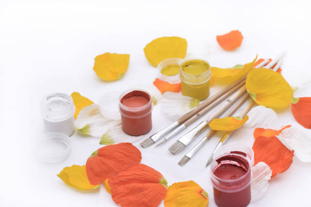 Colored abstraction of brushes for drawing. Flower leaves with gouache on white table.