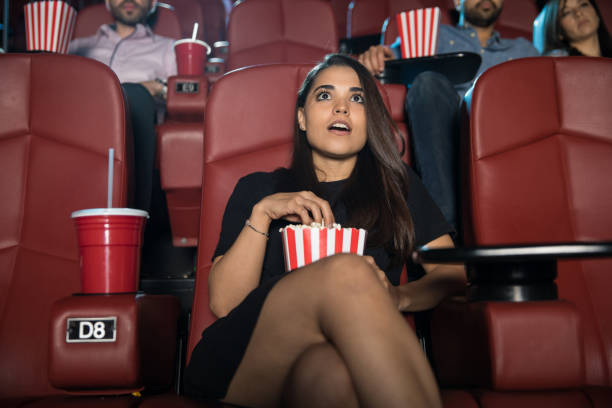 woman watching a scary movie - audience surprise movie theater shock imagens e fotografias de stock