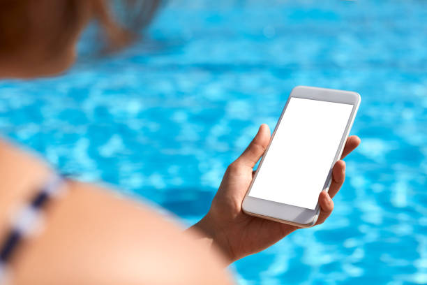 istock Woman using mobile phone by the pool 824037344