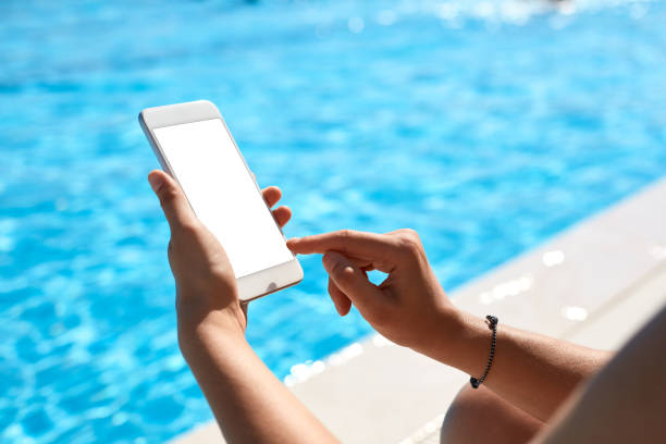 istock Woman using mobile phone by the pool 824037352