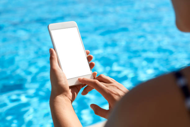 istock Woman using mobile phone by the pool 824037374