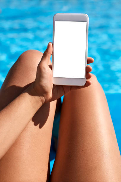 istock Woman using mobile phone by the pool 824037384