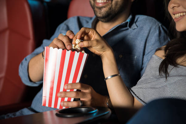 映画館でポップコーンを食べる - video sharing ストックフォトと画像