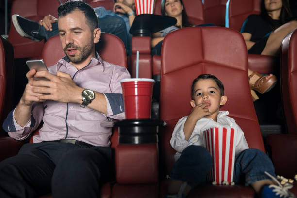istock Dad checking his phone at the movies 824040008