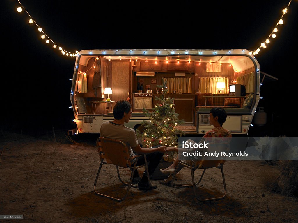 Mann und die Frau sitzt in der Nähe von Baum zu - Lizenzfrei Weihnachten Stock-Foto