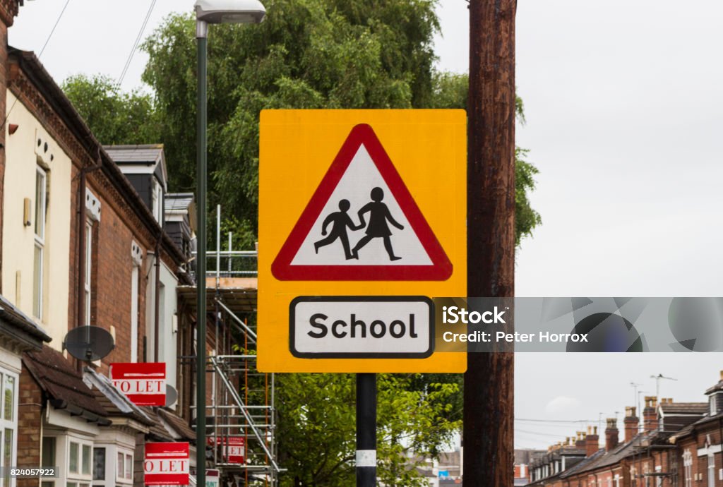 School children warning Warning traffic about school children crossing the road ahead School Building Stock Photo