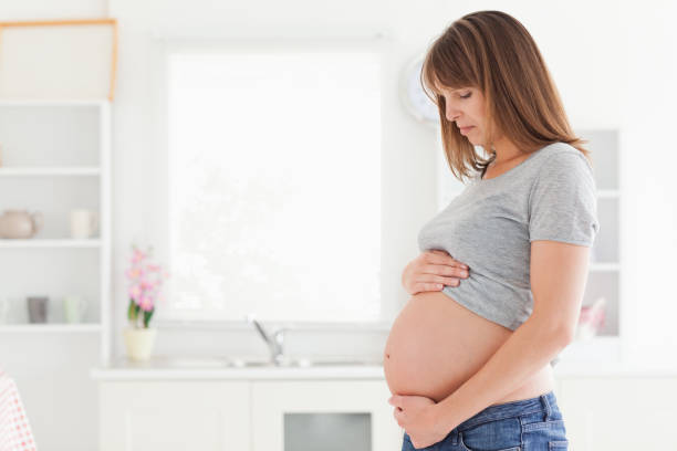 istock Attractive pregnant woman posing while caressing her belly 824063246
