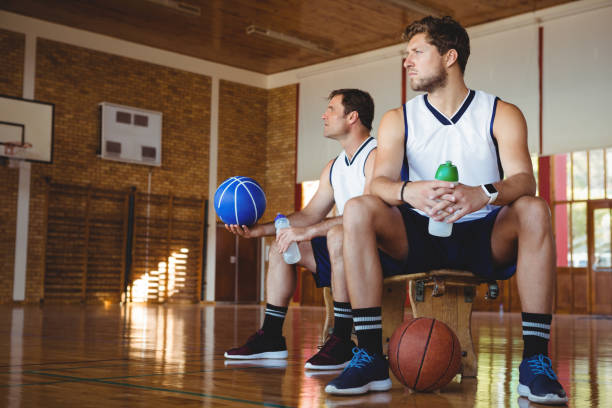 istock Thoughtful basketball players sitting on bench 824068512