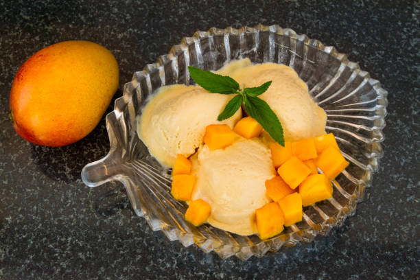 istock Mango ice cream with fresh mango slices with leaves mint on a glass plate. 824075796
