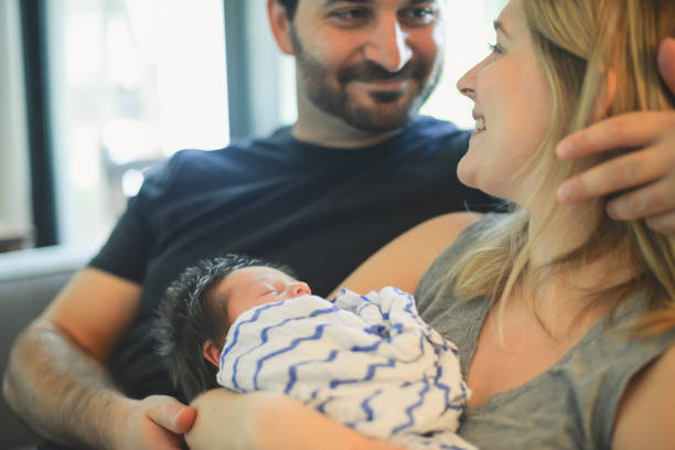Adorable young couple with their newborn baby bonding together