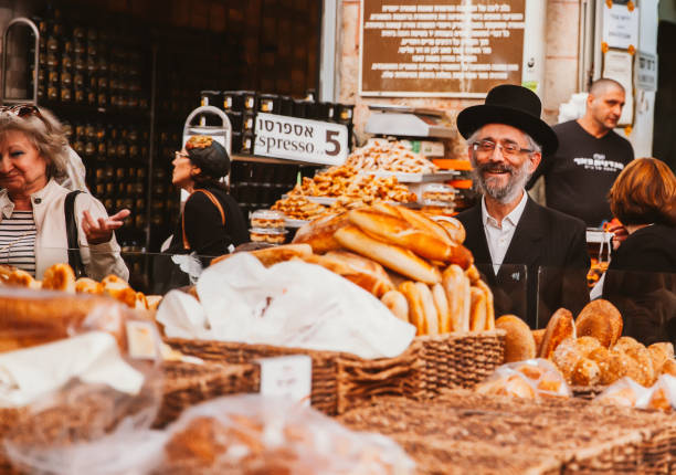 Mahane Yehuda Market Jerusalem, Israel- November 11, 2016: A man shopping for pastry, is talking with the vendor in a market stall at the famous Mahane Yehuda Market in dowtown Jerusalem with smiling face. rabbi photos stock pictures, royalty-free photos & images