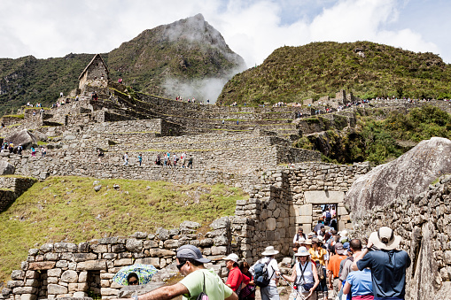 Tourists at the inca ruins of the sacred city of Machu Picchu