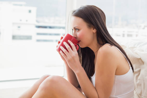 istock Pretty brunette sitting on floor with mug 824093910
