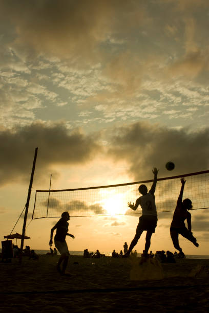 istock Friends playing volleyball at the beach with a sunset 824097508