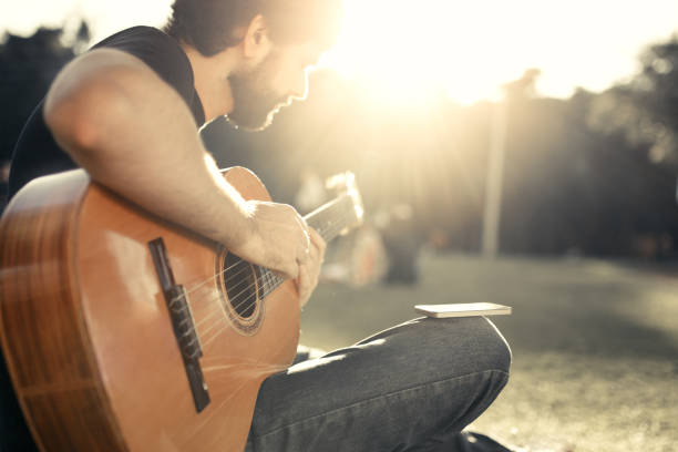 istock Playing the guitar at the park 824097854