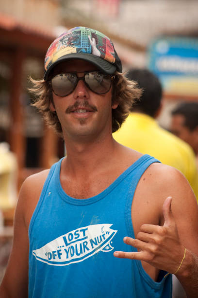 Montanita Portrait Montañita, Santa Elena, Ecuador - February 5, 2012: Portrait of a surfer tourist man walking at at the principal street on Montañita, Ecuador. Background some tiki stores. montanita ecuador stock pictures, royalty-free photos & images