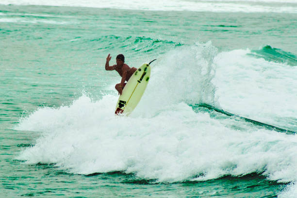 Montanita Mountaineer Ecuador Montañita Montanita, Santa Elena, Ecuador - February 4, 2012: Young surfer surfing at Montañita Montanita beach. montanita ecuador stock pictures, royalty-free photos & images