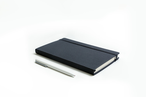 Notebook and white pen isolated on white background