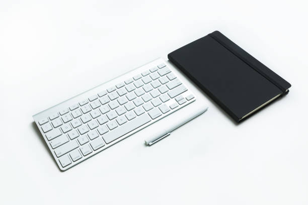 Modern aluminum computer keyboard and notebook stock photo