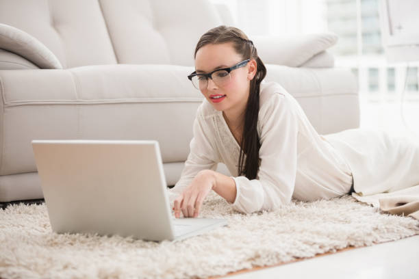 istock Pretty brunette using laptop on the floor 824122580