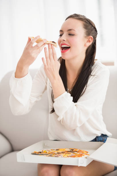 istock Pretty brunette eating slice of pizza 824122782