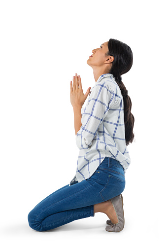 Side view of woman praying against white background