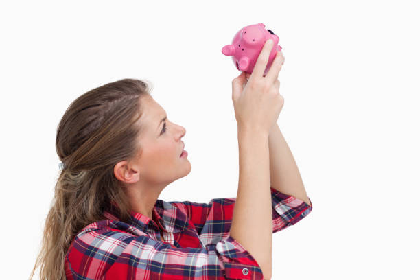 istock Woman looking inside a piggy bank 824126576
