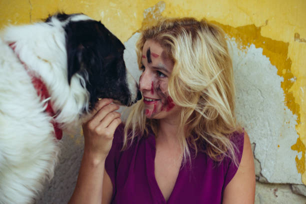 istock Woman with face paint playing with her dog 824132094