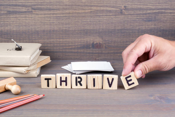 istock thrive. Wooden letters on dark background 824132946
