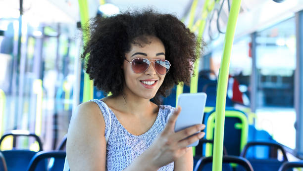 istock Smiling woman using smart phone inside of a bus 824133024