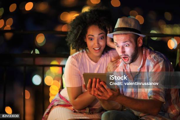 Couple Having Fun On Street Stock Photo - Download Image Now - Surprise, Computer, Friendship