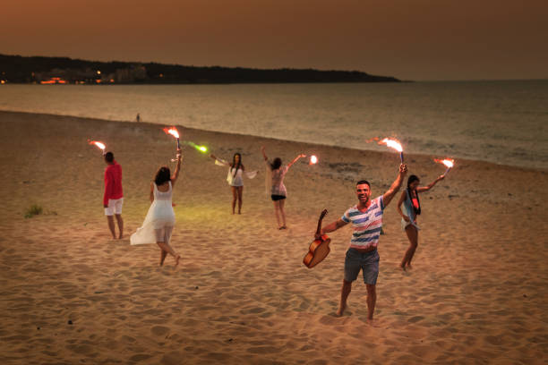 istock Friends celebrating with flaming torches on beach 824133112