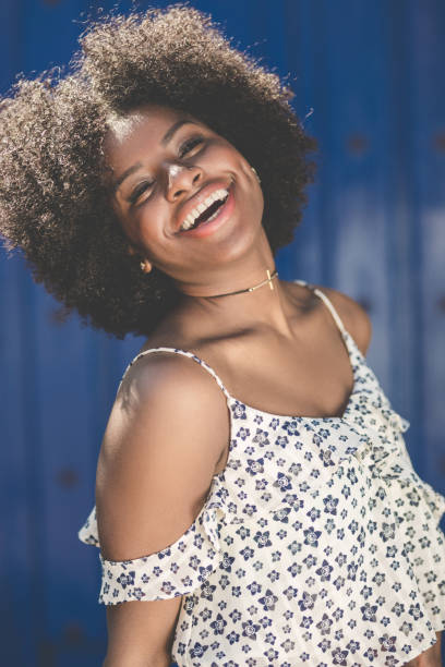 istock Pretty afro american woman on blue background laughing 824136580