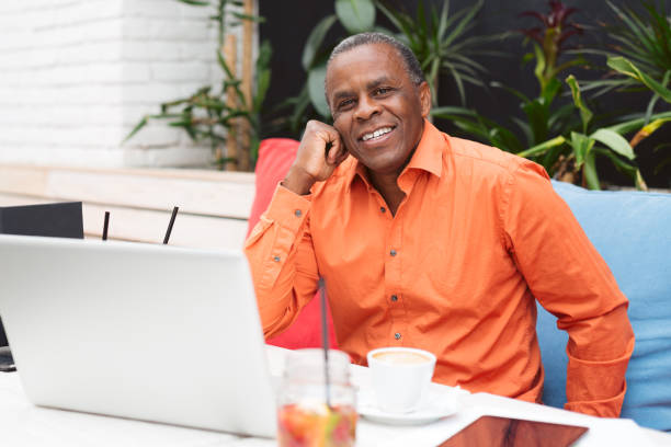 istock Black businessman with laptop at cafe 824137060