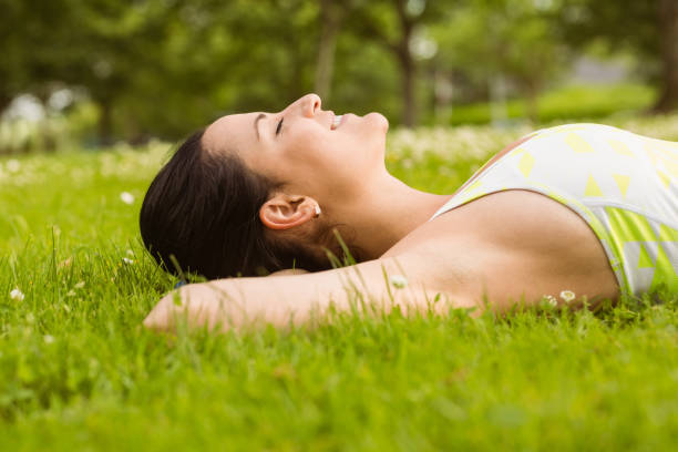 istock Peaceful fit brunette lying on the grass 824139502