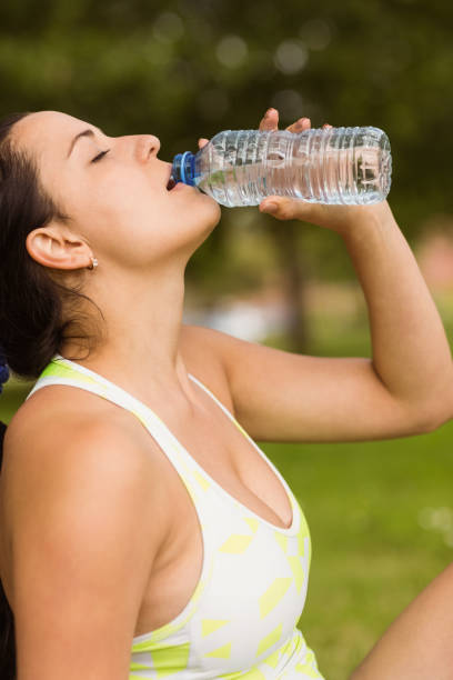 istock Fit brunette in sportswear drinking water 824139874