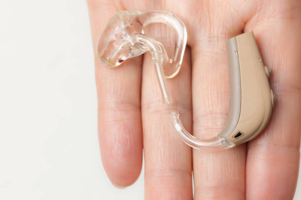 istock senior person holding hearing aid closeup 824150384