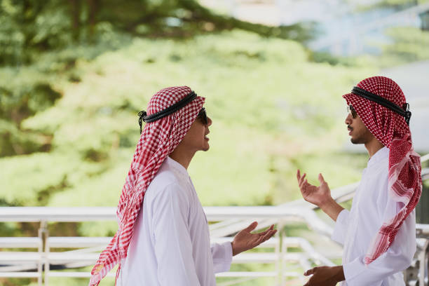 istock Two arab men are talking together with green background 824157642