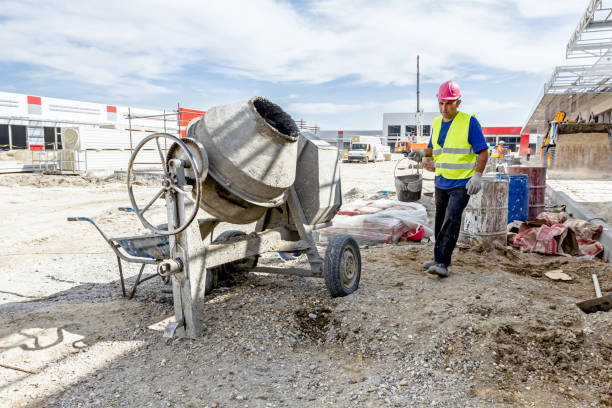 Cement mixer machine and wheelbarrow at building site Zrenjanin, Vojvodina, Serbia – July 28, 2015: Building activities during construction of the large complex shopping mall "AVIV PARK" in Zrenjanin city. sack barrow stock pictures, royalty-free photos & images