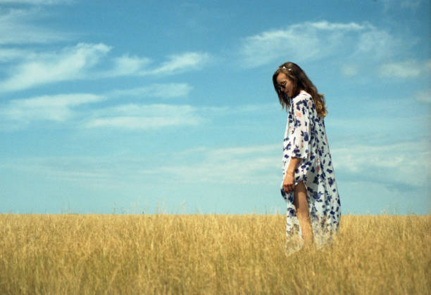 Beautiful caucasian brunette girl the flowers field in summer sunset Healthy Lifestyle
