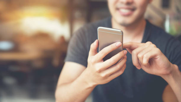 Happy man using smartphone and copy space Happy man using smartphone at modern coffee shop, he chatting Online Messaging on mobile phone. copy space text photography stock pictures, royalty-free photos & images