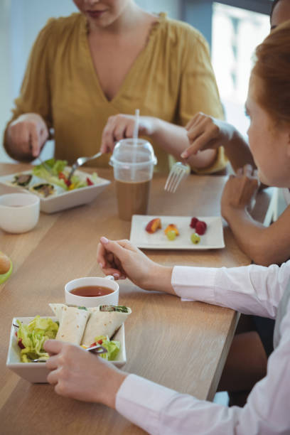 istock Female business colleagues having lunch at office cafeteria 824175834