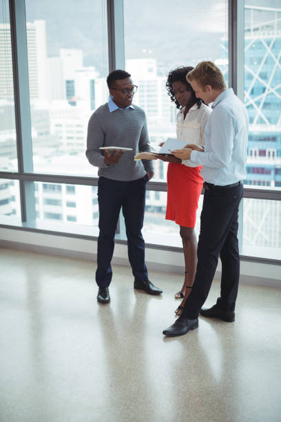 istock Young business people discussing by glass windows 824178958