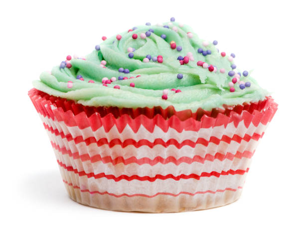istock Cupcake with green icing and hundreds and thousands against white background in front of white background 824179482